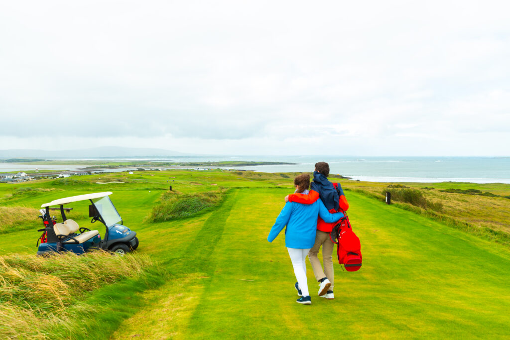 An image of a couple walking the course at County Sligo Golf Club in Failte, Ireland.