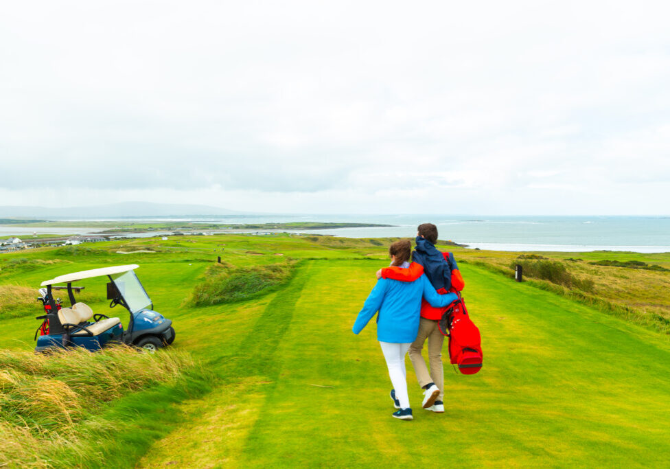 An image of a couple walking the course at County Sligo Golf Club in Failte, Ireland.